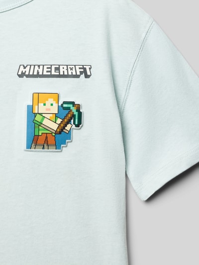 Junge trägt T-Shirt mit Motiv-Print von Mango in Reine Baumwolle, Regular Fit, mintgrün, Motiv-Print vorne, Nahaufnahme Oberkörper.