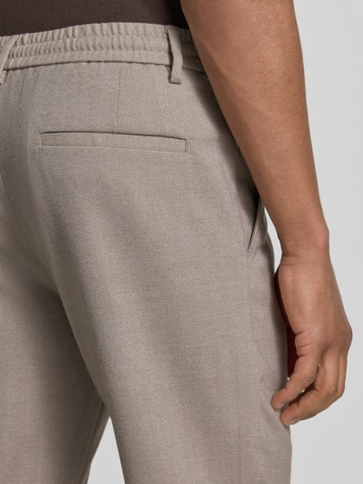 Männermodel trägt Slim Fit Stoffhose mit Viskose-Anteil von Lindbergh, Strukturmuster, Eingrifftaschen, Detailaufnahme Rückansicht.