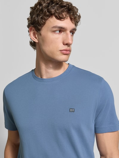 Männermodel trägt T-Shirt aus Baumwolle mit Rundhalsausschnitt von Christian Berg Men, Reine Baumwolle, Regular-Fit, Label-Detail, Nahaufnahme Oberkörper.