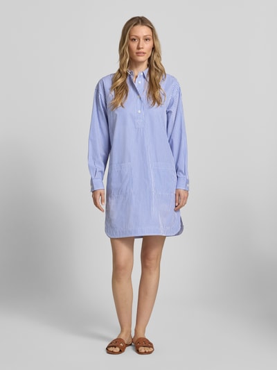Frauenmodel trägt Oversized Hemdblusenkleid aus reiner Baumwolle von Lauren Ralph Lauren mit blau-weißem Streifenmuster, Mini-Länge, Knopfleiste, langen Ärmeln und Twillstruktur, Ganzkörperansicht von vorne.
