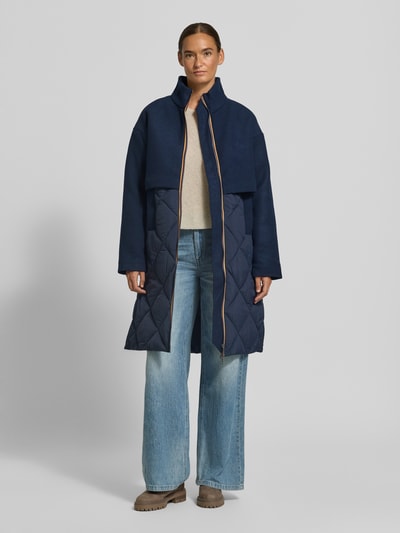 Modelka nosi Regular Fit Mantel aus Woll-Mix Modell 'MINDY' von K-WAY w kolorze granatowym, steppowana faktura, stojący kołnierz, krój regular fit, długość tyłu w rozmiarze S: 100 cm, szerokość ramion w rozmiarze S: 56 cm, szerokość klatki piersiowej w rozmiarze S: 53 cm, długość rękawa w rozmiarze S: 56 cm, widok całej sylwetki z przodu.