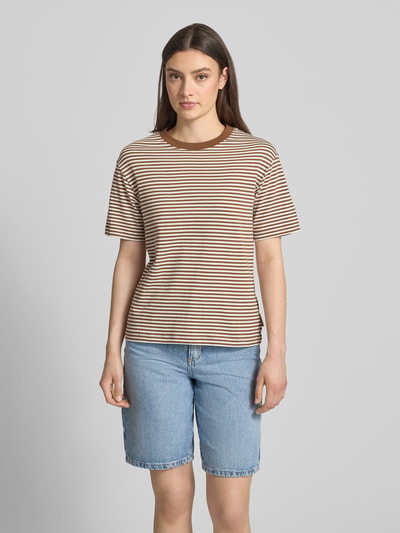 Modelka kobieca ma na sobie Regular Fit T-Shirt aus reiner Baumwolle von Marc O'Polo Denim, brązowo-beżowe paski, krój regular fit, okrągły dekolt, krótki rękaw, całość z czystej bawełny, widok całej sylwetki z przodu.