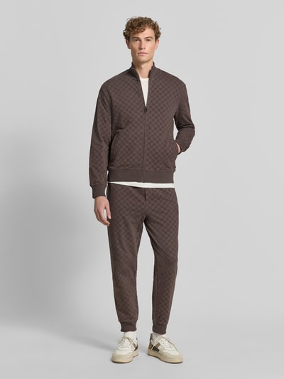 Männermodel trägt Loose Fit Sweatjacke aus Baumwoll-Mix Modell 'Kend' von JOOP! COLLECTION in Braun mit Rauten-Struktur, Ganzkörperansicht von vorne.