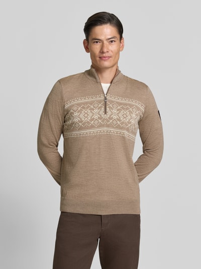 Männermodel trägt Wollpullover mit Label-Patch Modell 'Liaset' von Dale of Norway, Beige mit Norwegermuster, Nahaufnahme Oberkörper.