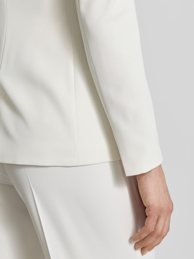 Kobieta nosi Blazer mit Reverskragen und Pattentaschen od Jake*s Cocktail, biały materiał z domieszką stretchu, detal rękawa, zbliżenie na dolną część ręki.