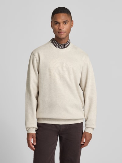 Mannelijk model draagt Sweatshirt met Label-Print van Guess in beige, katoenmix, regular fit, geribbelde boorden, rond hals, vooraanzicht.