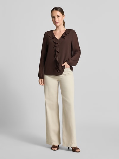 Frauenmodel trägt Regular Fit Langarmbluse in Crêpe-Optik von s.Oliver BLACK LABEL, braun, mit Rüschen, helle Hose, Ganzkörperansicht von vorne.