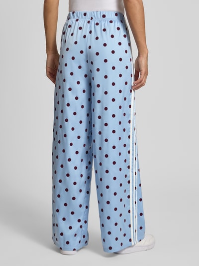 Frauenmodel trägt Loose Fit Sweatpants mit Polka Dots Modell 'CLESKY' von adidas Originals, Optik:Allover-Muster, Satin, Ganzkörperansicht Rückansicht.