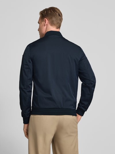 Männermodel trägt Bomberjacke mit Reißverschlusstaschen von Geox in Dunkelblau, Regular-Fit, Stehkragen, Rückansicht, Rückenlänge 68 cm, Schulterbreite 46 cm, Brustweite 45 cm, Ärmellänge 64 cm, Größe M. Ganzkörperansicht Rückansicht.