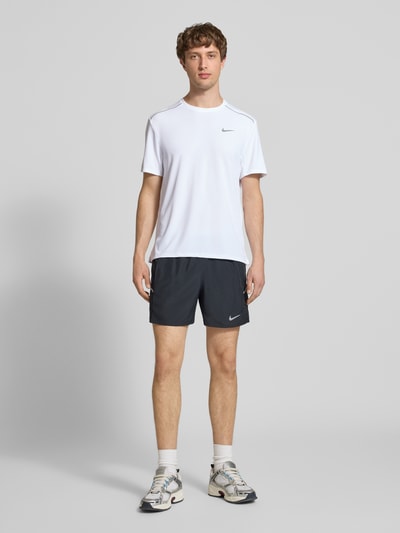 Männermodel trägt T-Shirt mit Rundhalsausschnitt und Logo von NIKE TRAINING, Regular-Fit, Kontraststreifen, Rückenlänge 74 cm, Ganzkörperansicht von vorne.
