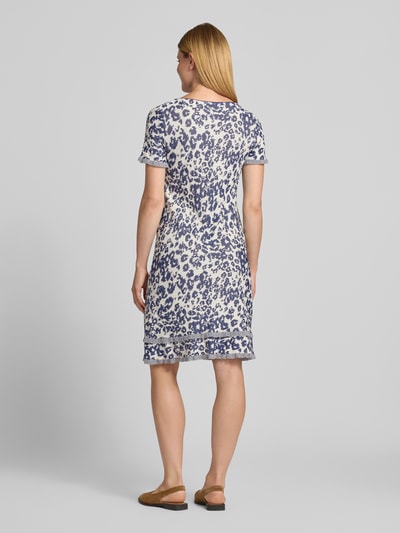 Modelka nosi Knielanges Strickkleid aus Viskose-Mix im Allover-Look von Marc Cain, Mieszanka wiskozy, Linia a, Długość do kolan, wzór na całej powierzchni, okrągły dekolt, Długość tyłu w rozmiarze 36: 101 cm, Szerokość w rozmiarze 36: 43 cm, Długość rękawów w rozmiarze 36: 22 cm, widok całej sylwetki z tyłu.