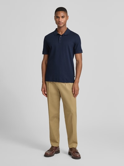 Männermodel draagt Poloshirt mit kurzer Knopfleiste Modell 'Roni' van JOOP! Collection, donkerblauw, regular fit, katoen, voorkant, Ganzkörperansicht von vorne.