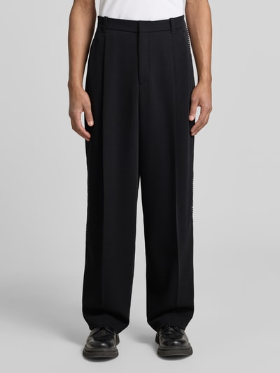 Männermodel trägt Wide Fit Hose mit Bundfalten und Schurwoll-Anteil Modell 'FEDIX' von HUGO in Two-Tone-Optik, Twill, Ganzkörperansicht von vorne.