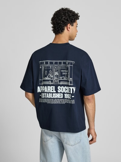 Männermodel trägt T-Shirt mit Rundhalsausschnitt und Logo-Print von REVIEW in Dunkelblau, reine Baumwolle, Modern Fit, Rückenansicht, Rückenlänge 68 cm bei Größe M.