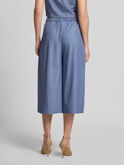 Frauenmodel trägt Culotte mit Biesen und Eingrifftaschen von Rinascimento in Hellblau, elastischer Bund, Loose Fit, Ganzkörperansicht Rückansicht.