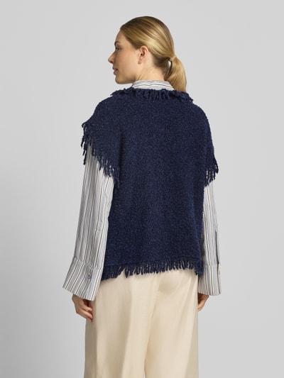 Vrouwenmodel draagt mouwloos vest van wolmix met franjes, regular fit, opgestikte zakken, ruglengte maat S 57 cm, van Milano Italy. Ganzkörperansicht Rückansicht