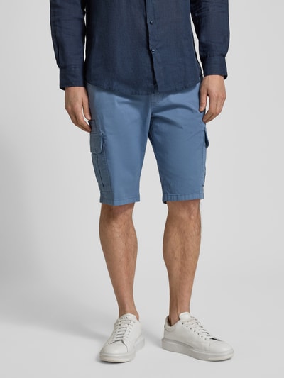 Męski model nosi Bermudas mit Cargotaschen od bugatti, krój regular fit, kieszenie cargo, kolor niebieski, zdjęcie całej sylwetki z przodu.
