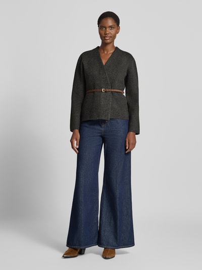 Frauenmodel trägt Regular Fit Strickjacke mit Woll-Anteil von Jake*s Collection in dunklem Grau, kombiniert mit blauer Jeans, Ganzkörperansicht von vorne.