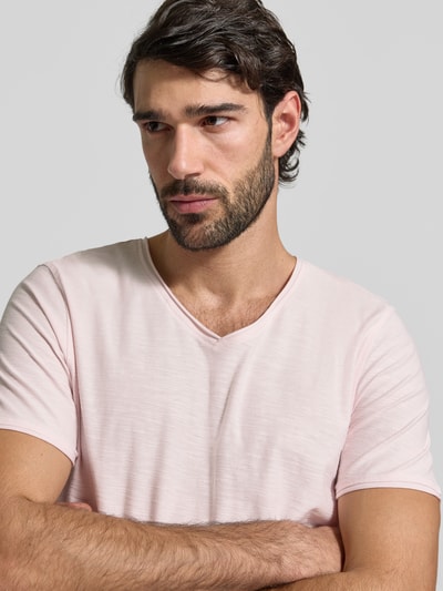 Männermodel trägt T-Shirt mit geripptem Rundhalsausschnitt von MCNEAL in Rosa, Regular-Fit, Rückenlänge 65 cm, Nahaufnahme Oberkörper.