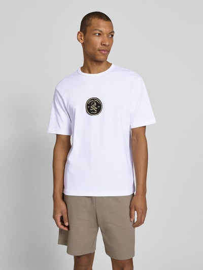 Männermodel trägt weißes Regular Fit T-Shirt aus reiner Baumwolle Modell 'DOBUL' von HUGO, Rundhals, Label Stitching, Ganzkörperansicht von vorne.