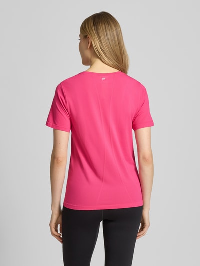 Frauenmodel trägt Regular Fit T-Shirt mit Rundhalsausschnitt Modell 'Feather' von Fabletics, Damen T-Shirt aus Elastischer-Material-Mix in Pink mit glatter Textur, Rückenlänge bei Größe S 54 cm, Ganzkörperansicht Rückansicht.