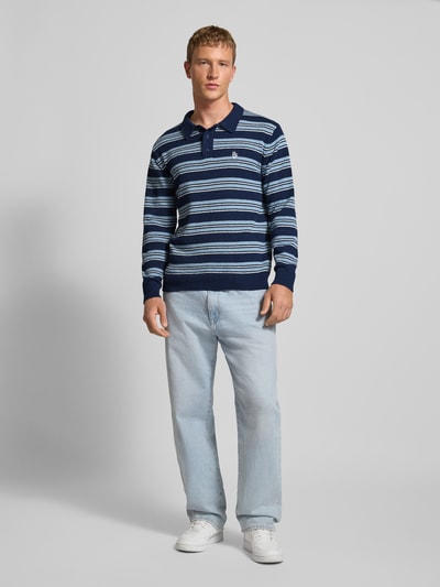 Männermodel trägt Strickpullover mit Polokragen in Bouclé-Optik von REVIEW, Regular-Fit, Streifenmuster, Label-Stitching, Ganzkörperansicht von vorne.