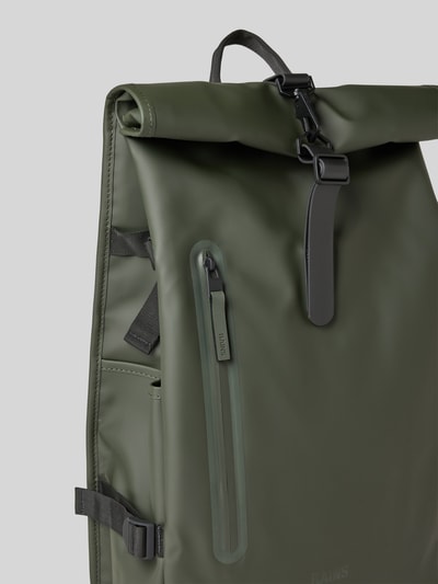 Produktfoto, Rolltop Rucksack mit Reißverschlusstasche von Rains in Olivgrün, Karabinerhaken, Tragehenkel, verstellbare Träger, Maße 31x61x15 cm, Schulterriemen 74 cm.