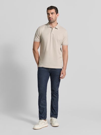 Männermodel trägt Regular Fit Poloshirt mit Label-Stitching von Fynch-Hatton, beige, reine Baumwolle, Knopfleiste, Ganzkörperansicht von vorne.