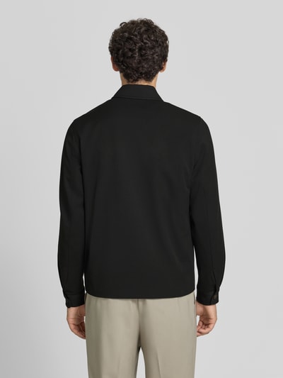 Männermodel trägt Jacke mit Logo-Stitching Modell 'Como' von Les Deux in Schwarz, gerade Passform, Rückansicht, Material-Mix mit Viskose-Anteil.