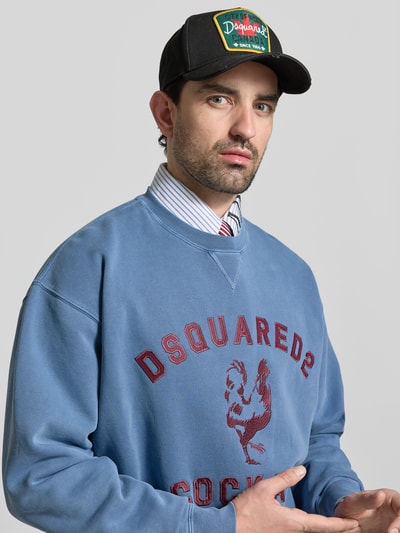 Männermodel trägt Regular Fit Sweatshirt mit Logo-Detail von Dsquared2 in Blau, reine Baumwolle, Rundhalsausschnitt, Nahaufnahme Oberkörper.