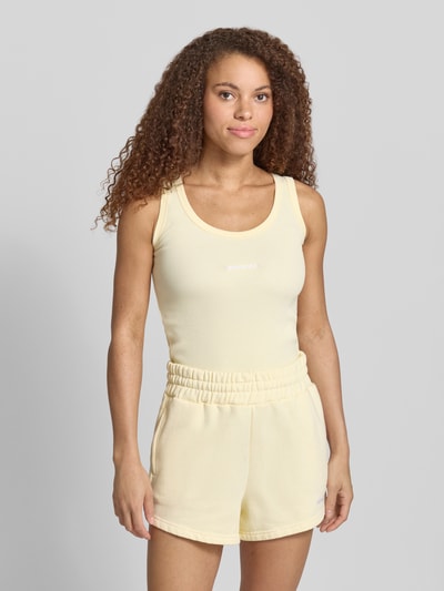 Frauenmodel trägt Tanktop mit Logo-Stitching Modell 'CESIS' von Pegador aus Baumwoll-Mix mit Stretch-Anteil, Körpernaher-Schnitt, Feinripp, Rundhalsausschnitt, Rückenlänge bei Größe S: 52 cm, Ganzkörperansicht von vorne.