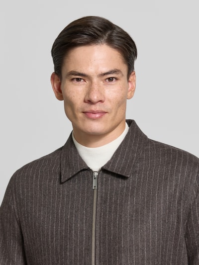 Männermodel trägt Regular Fit Jacke aus Woll-Mix mit Umlegekragen Modell 'Barnaby' von Tiger of Sweden in Braun mit feiner Streifenstruktur, Nahaufnahme Oberkörper. Herren Jacke, Zweiwege-Reißverschluss, dezente Textur, Größe M: Rückenlänge 66 cm, Schulter 44 cm, Brust 56 cm, Ärmel 66 cm.