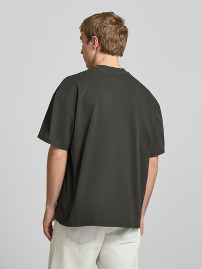 Männermodel trägt T-Shirt mit Logo-Print Modell 'PLAINVILLE' von Dickies in Dunkelgrau, Relaxed Fit, Baumwolle, Ganzkörperansicht Rückansicht.