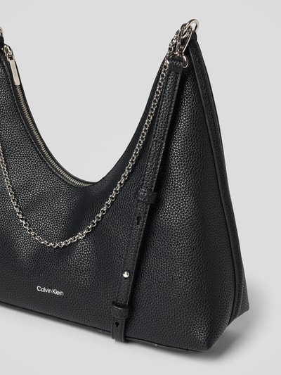 Produktfoto, Handtasche mit Label-Detail von CK Calvin Klein, strukturiertes schwarzes Leder, silberner Kettenschulterriemen, Szerokość w rozmiarze 1: 24 cm, długość 27 cm, głębokość 11 cm, długość paska 68 cm, komora główna i wewnętrzna na zamek