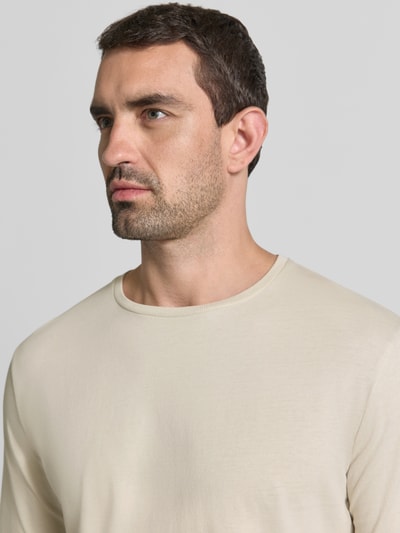 Männermodel trägt Regular Fit Longsleeve aus reiner Baumwolle Modell 'Kendrick' von Drykorn, dezentes Beige, glatte Textur, Nahaufnahme Oberkörper. Herren Longsleeve, Rundhalsausschnitt, Rückenlänge bei Größe M 70 cm.