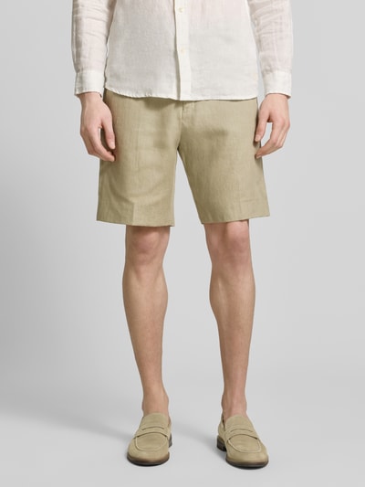 Männermodel trägt Shorts mit französischen Eingrifftaschen Modell 'Troy' von Tiger Of Sweden in Beige, gerader Schnitt, Ganzkörperansicht von vorne.