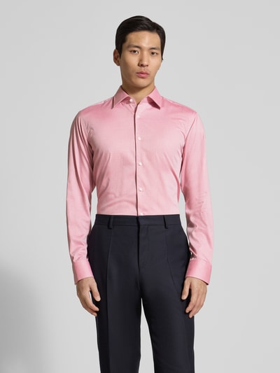 Männermodel trägt Regular Fit vrijetijdsoverhemd uit katoenmix model 'H-JOE-K-C1-261' van BOSS met all-over motief, geruit patroon, kentkraag, doorlopende knoopsluiting, labelstitching, lange mouwen met verstelbare manchet, afgeronde rompzoom, popeline materiaalverwerking, voorkant geheel in beeld, frontale geheelopname.