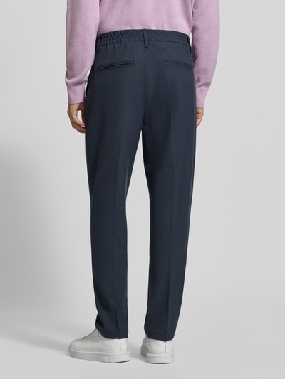 Männermodel trägt stoffen broek met persplooien Model 'MARC' van Casual Friday, Materiaalmix met viscose, straight fit, elastische band, knoop- en ritssluiting, Franse steekzakken, strookzak aan de achterkant, bandwijdte maat 32/32: 43 cm, binnenbeenlengte maat 32/32: 76 cm, donkere kleur, gladde textuur, Ganzkörperansicht Rückansicht.