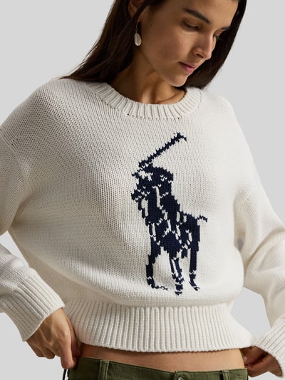 Frauenmodel trägt Regular Fit Strickpullover aus reiner Baumwolle von Polo Ralph Lauren in Two Tone Optik, große Pony-Applikation, Nahaufnahme Oberkörper.