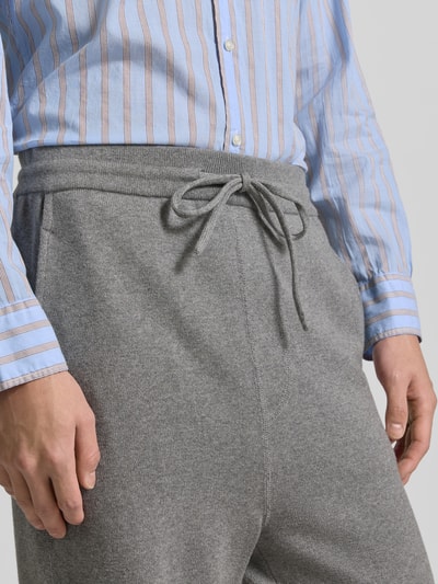 Männermodel trägt Wide Fit Sweathose mit Kaschmir-Anteil von Officine Générale, grau, Strick-Optik, Nahaufnahme Oberkörper. Baumwoll-Mix, elastischer Bund, Eingrifftaschen.