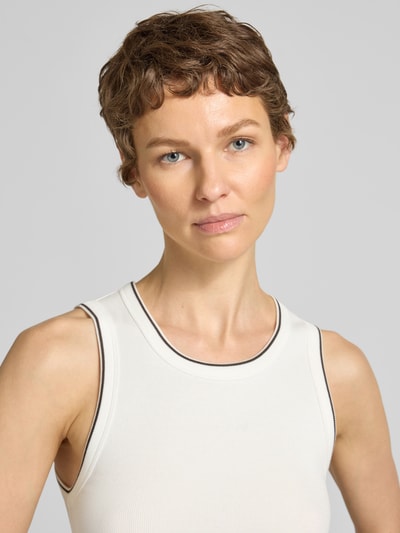 Frauenmodel trägt Trägertop in Ripp-Optik Modell 'Ilesso springclub' von OPUS in Weiß mit feiner Struktur, Nahaufnahme Oberkörper. Baumwoll-Elasthan-Mix, Slim Fit, Rundhalsausschnitt.