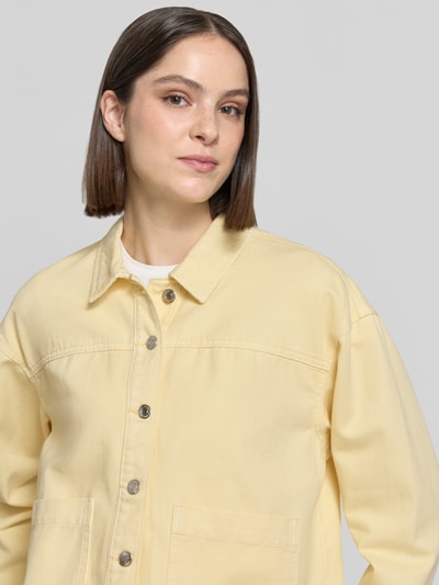 Frauenmodel trägt Regular Fit Overshirt aus reiner Baumwolle Modell 'JAMIE' von Vero Moda in gelber Denim-Optik, Nahaufnahme Oberkörper.