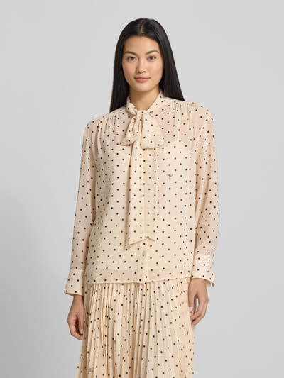 Vrouwenmodel draagt strikblouse in all-over look model 'Bo' van JOOP!, regular fit, lichtbeige met zwarte stippen, ruglengte 64 cm, mouwlengte 56 cm, voorkant bovenlichaam close-up.