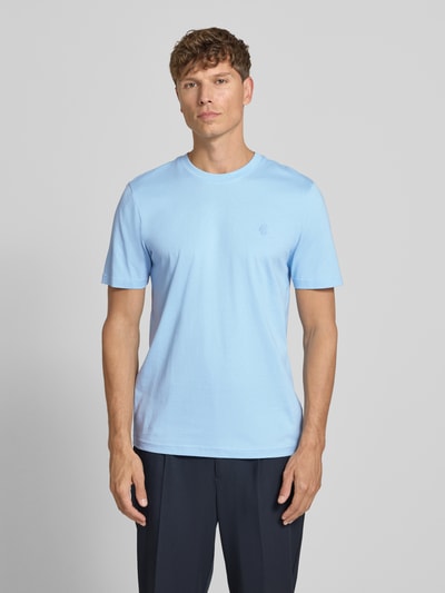 Męski model nosi Regular Fit T-Shirt mit Logo-Stitching von MCNEAL, bawełna, krój regular fit, okrągły dekolt, długość tyłu 70 cm w rozmiarze M, widok całej sylwetki z przodu.