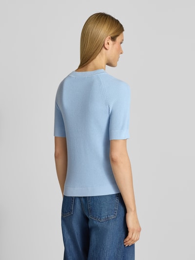 Frauenmodel trägt Regular Fit Strickpullover aus Viskose-Baumwoll-Mix Modell 'ELINNA' von Selected Femme, hellblau, Strukturmuster, gerippte Abschlüsse, unifarben, Crew Neck, kurzarm, Ganzkörperansicht Rückansicht.