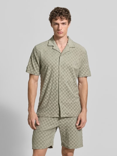 Męski model nosi Regular Fit Freizeithemd mit Reverskragen von Lindbergh z mieszanki bawełny, listwa guzikowa, koszula casualowa, długość tyłu w rozmiarze M 73 cm, szerokość ramion w rozmiarze M 48 cm, długość rękawów w rozmiarze M 27 cm, wzór w kratę, jasnobeżowe odcienie, faktura miękka, całkowity widok z przodu.