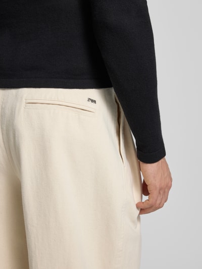 Männermodel trägt Stoffhose mit französischen Eingrifftaschen von Emporio Armani, Reine Baumwolle, Gerader Schnitt, Detailaufnahme Rückansicht.