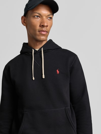 Mannelijk model draagt Regular Fit Hoodie uit katoenmix van Polo Ralph Lauren in zwart met rood logo, close-up bovenlichaam, Heren hoodie.