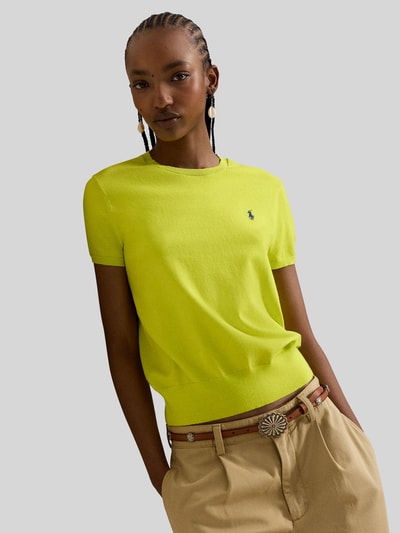 Frauenmodel trägt Regular Fit Kurzarmpullover mit Logo-Stitching von Polo Ralph Lauren in Neongelb, Rundhalsausschnitt, elastischer Baumwoll-Mix, elastische Ärmelabschlüsse, beige Hose, Nahaufnahme Oberkörper.