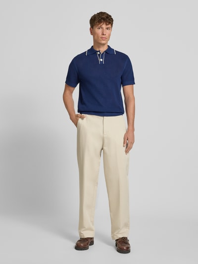 Männermodel trägt dunkelblaues Regular-Fit Poloshirt aus reiner Baumwolle Modell 'JESSE' von Selected Homme, Ganzkörperansicht von vorne. Herren Poloshirt.